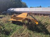 le tracteur est garé dans l'herbe, à côté d'un bâtiment