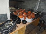 de nombreuses casseroles et poêles posées sur une table dans la cuisine
