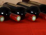 several bottles of wine are lined up on a red table cloth