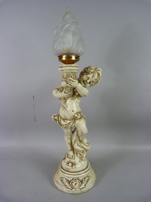 un bougeoir blanc surmonté d'une statuette