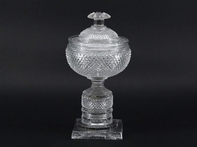 a clear glass vase with a bird on top of it
