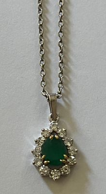un gros plan d'un collier composé d'une pierre verte montée sur une chaîne