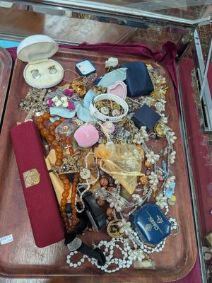 une valise remplie de bijoux et d'autres objets, posée par terre