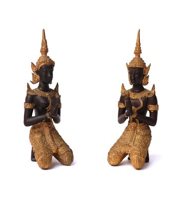 pair of black and gold statues of a man and a woman sitting on their knees