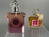 two bottles of perfume sitting on a clear table