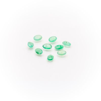 a group of green glass beads on a white surface