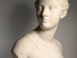 a white marble bust of a woman with her eyes closed
