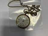 une petite montre de poche munie d'une chaîne