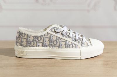 the white and grey sneakers are on a wooden table
