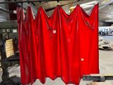a red curtain hanging on a rack in a warehouse