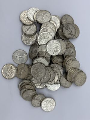 tas de pièces d'argent sur une surface blanche