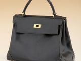 a black leather handbag with gold hardware on the handle