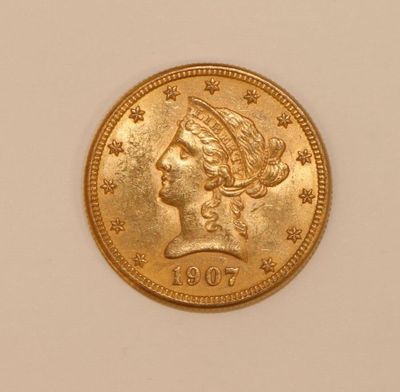 a close up of a gold coin with a woman ' s head on it