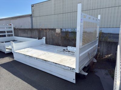 une benne de camion blanche garée au milieu d'un parking