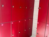 several red lockers are lined up in a row in a bathroom