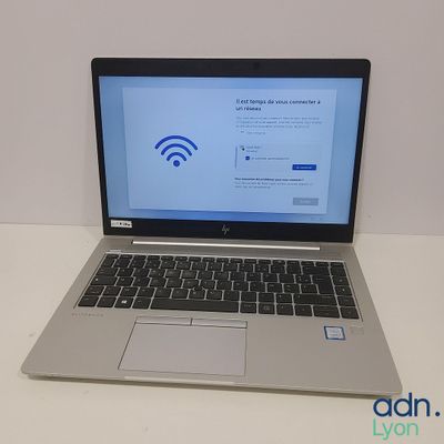 un ordinateur portable posé sur une table, avec le symbole du Wi-Fi affiché à l'écran
