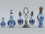 Plusieurs vases bleus et blancs sont alignés sur une surface blanche
