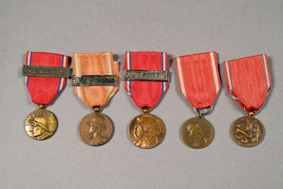 four medals are placed on a gray surface with a red ribbon