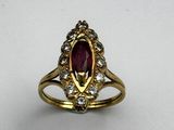 a close up of a gold ring with a red stone