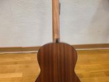 an acoustic guitar sits on a stand in a room
