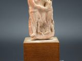 une statue antique représentant un homme tenant une femme dans ses bras, posée sur un socle