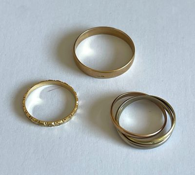 trois bagues posées sur une table avec un fond blanc