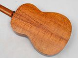 a close up of a wooden guitar on a white surface