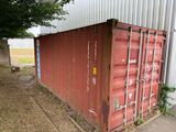a red shipping container that is sitting outside of a building