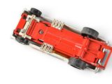 a red toy car that is sitting on a white surface