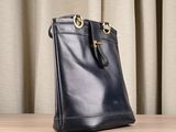 a black handbag sitting on top of a wooden table