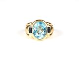 Gros plan sur une bague en or ornée d'une topaze bleue