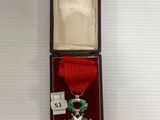 l'image d'une médaille dans une boîte entourée d'un ruban
