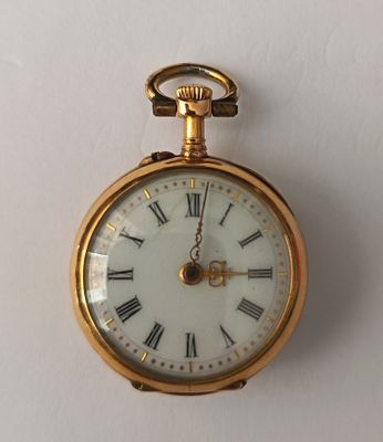 une montre de poche en or avec des chiffres romains sur le cadran