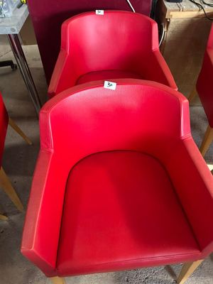 Plusieurs chaises rouges sont alignées en rang dans une pièce