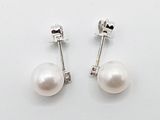 une paire de boucles d'oreilles en perles blanches sur fond blanc