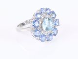 a close up of a ring with blue and white stones on a white background