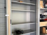 une armoire métallique avec des étagères, au milieu d'un garage