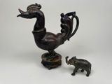une petite statue représentant un oiseau et un éléphant, posée sur une table