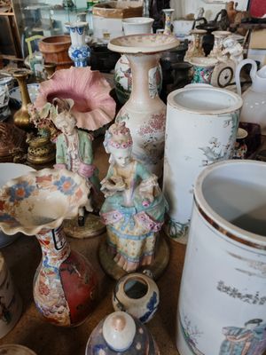 il y a de nombreux vases sur la table dans cette pièce