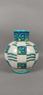 un vase blanc orné de motifs bleus et jaunes