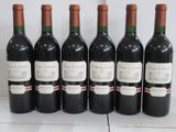 six bottles of wine are lined up on a table