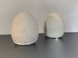 deux vases blancs posés sur une table, avec un mur blanc en arrière-plan