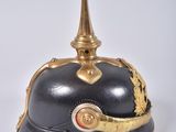 an old helmet with a gold decoration on the top of it