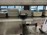 many plates and pans on the counter in the kitchen