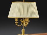 une image représentant une lampe posée sur un bureau, surmontée d'un abat-jour