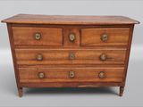 une commode ancienne à quatre tiroirs, dotée de boutons en laiton