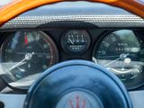 a close up of a steering wheel with a clock on it