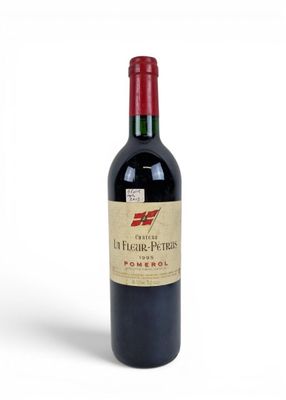 a bottle of red wine sitting on top of a white table