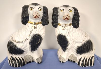 pair of black and white dog figurines sitting on blue cloth