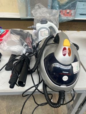 un fer à repasser à vapeur noir et argent posé sur une table